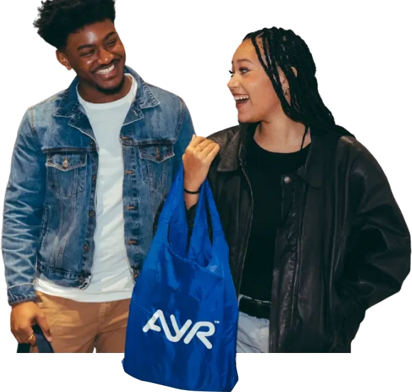 Two smiling Ayr customers walking with a blue Ayr shopping bag