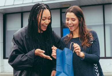 Two women with Ayr gift bag